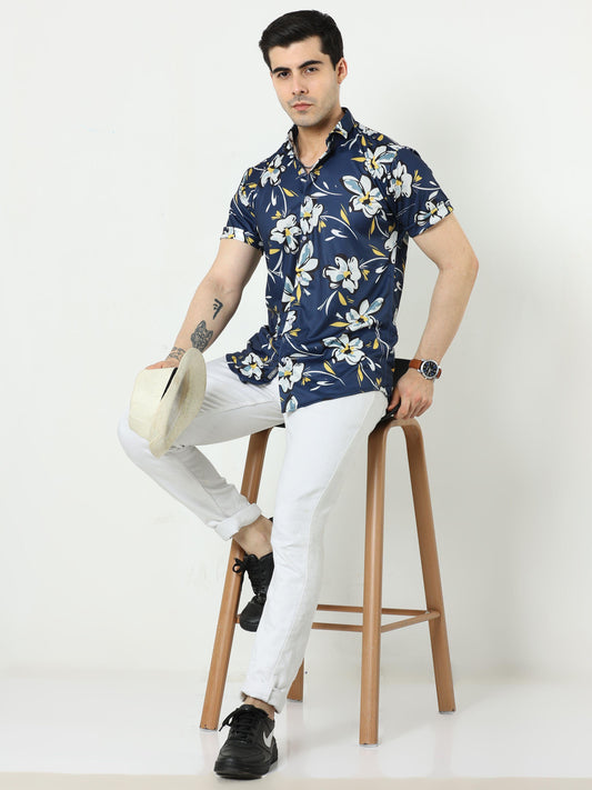 Navy blue floral print casual shirt for men, featuring a spread collar and a model sitting on a stool against a white background.