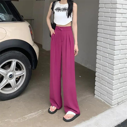 Women's comfortable high-waist loose straight wide-leg pink pants with white crop top and black and white patterned sleeveless shirt showcased in a garage setting.