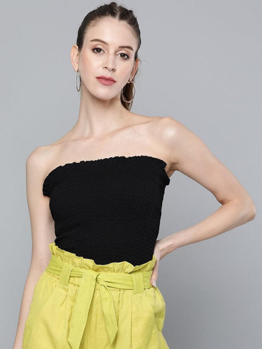 Stylish black tube top and bright yellow pants worn by model against gray background
