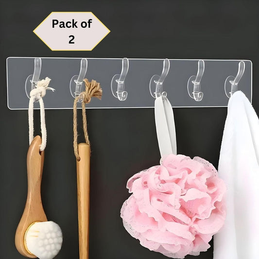 Pack of 2 clear plastic wall hanger hooks displaying various bathroom accessories, including a pink flower decoration, on a black background.